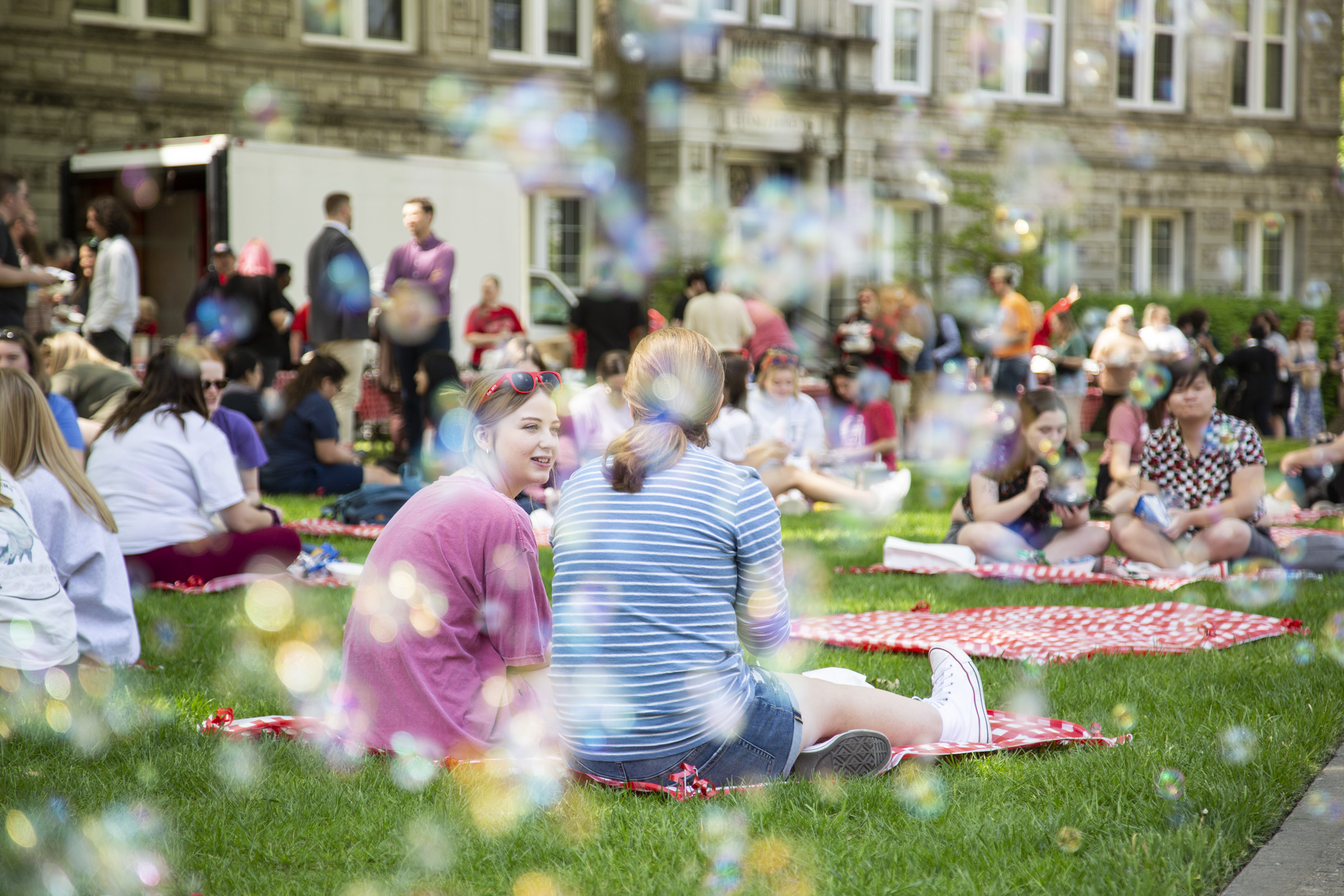 Students enjoy a picnic on the lawn. 