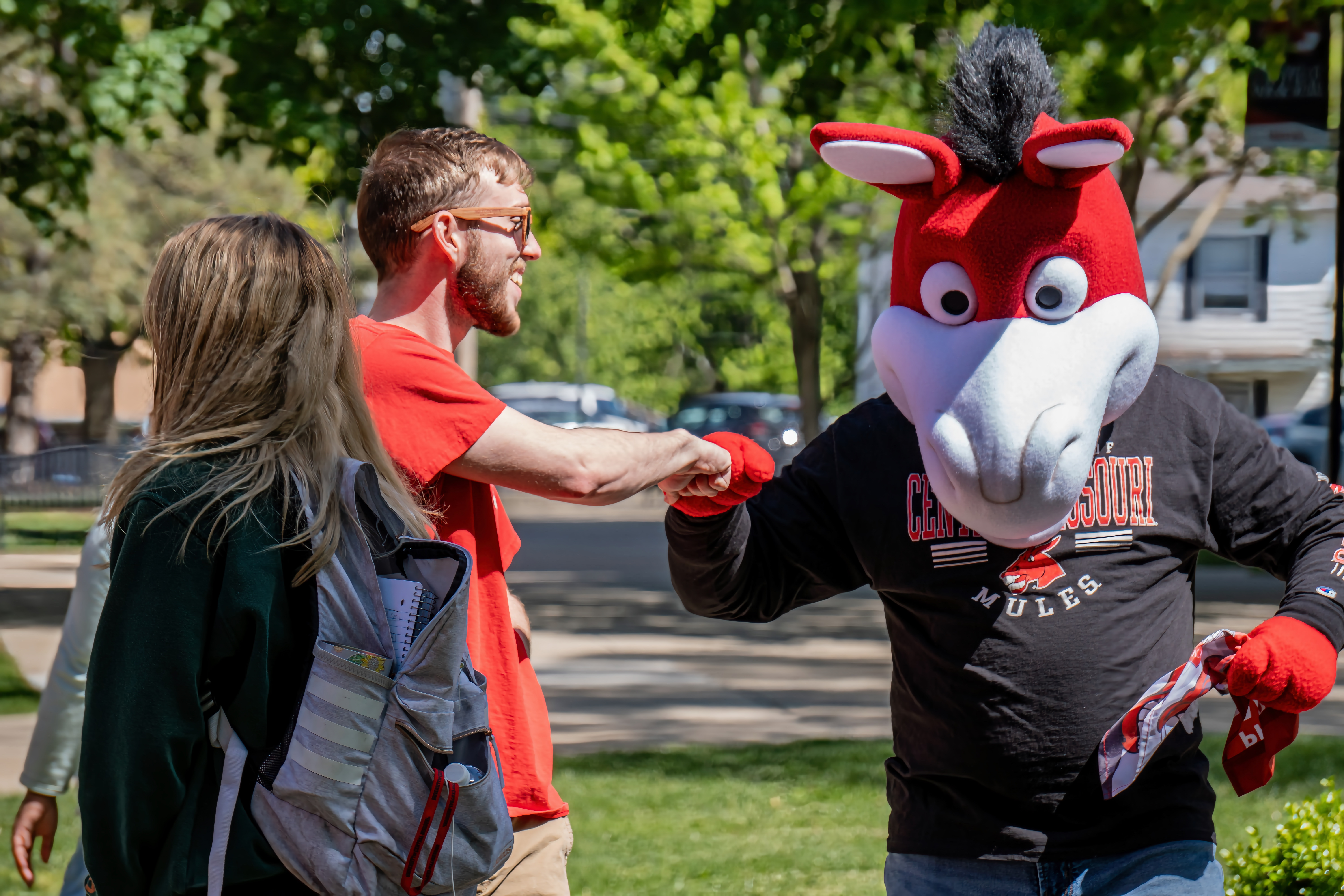 Mo the Mule fist bumps a student.