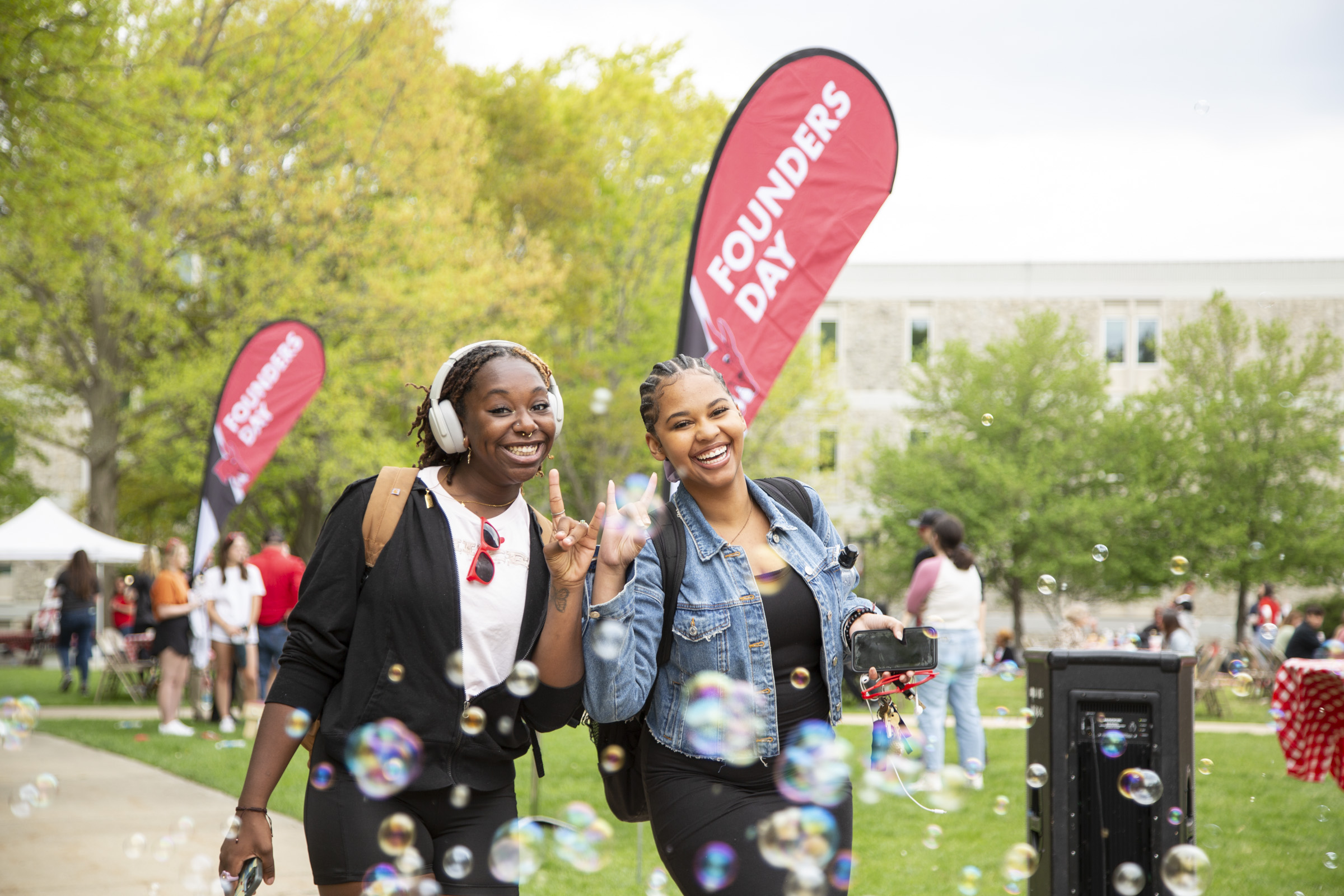 Two students walk through bubbles in the Quad.
