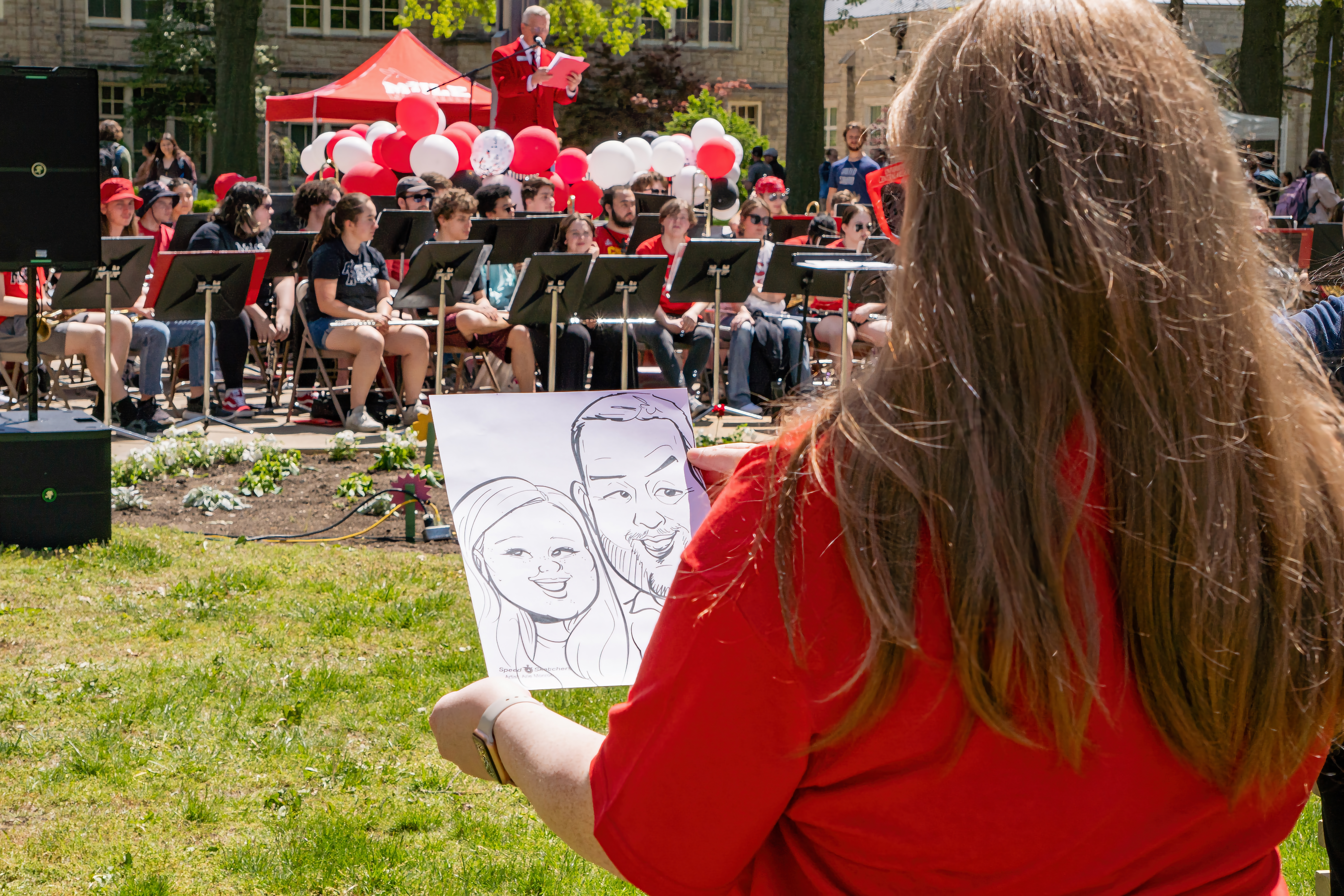 A student holds up a caricature drawing.