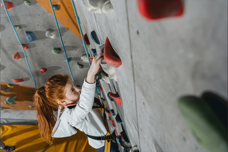 A student climbing a rock wall