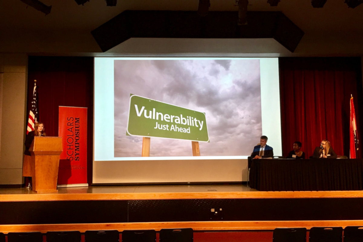 Large panel presentation, with student speaking at a podium.