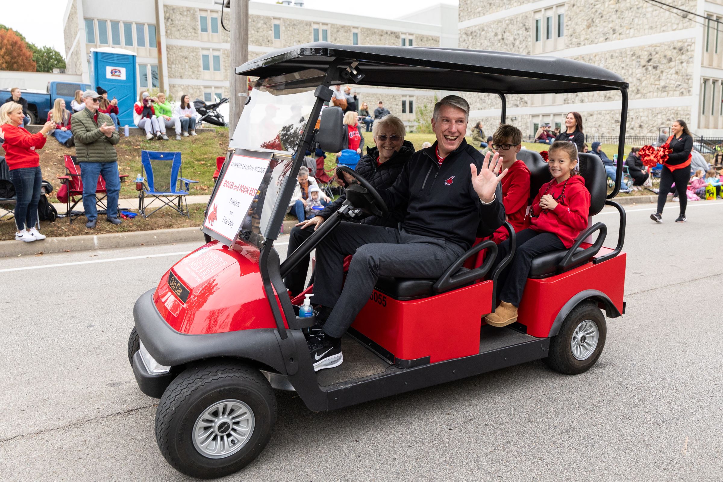 UCM President Roger Best, First Lady Robin Best and their grandkids on a golf cart in the Homecoming parade