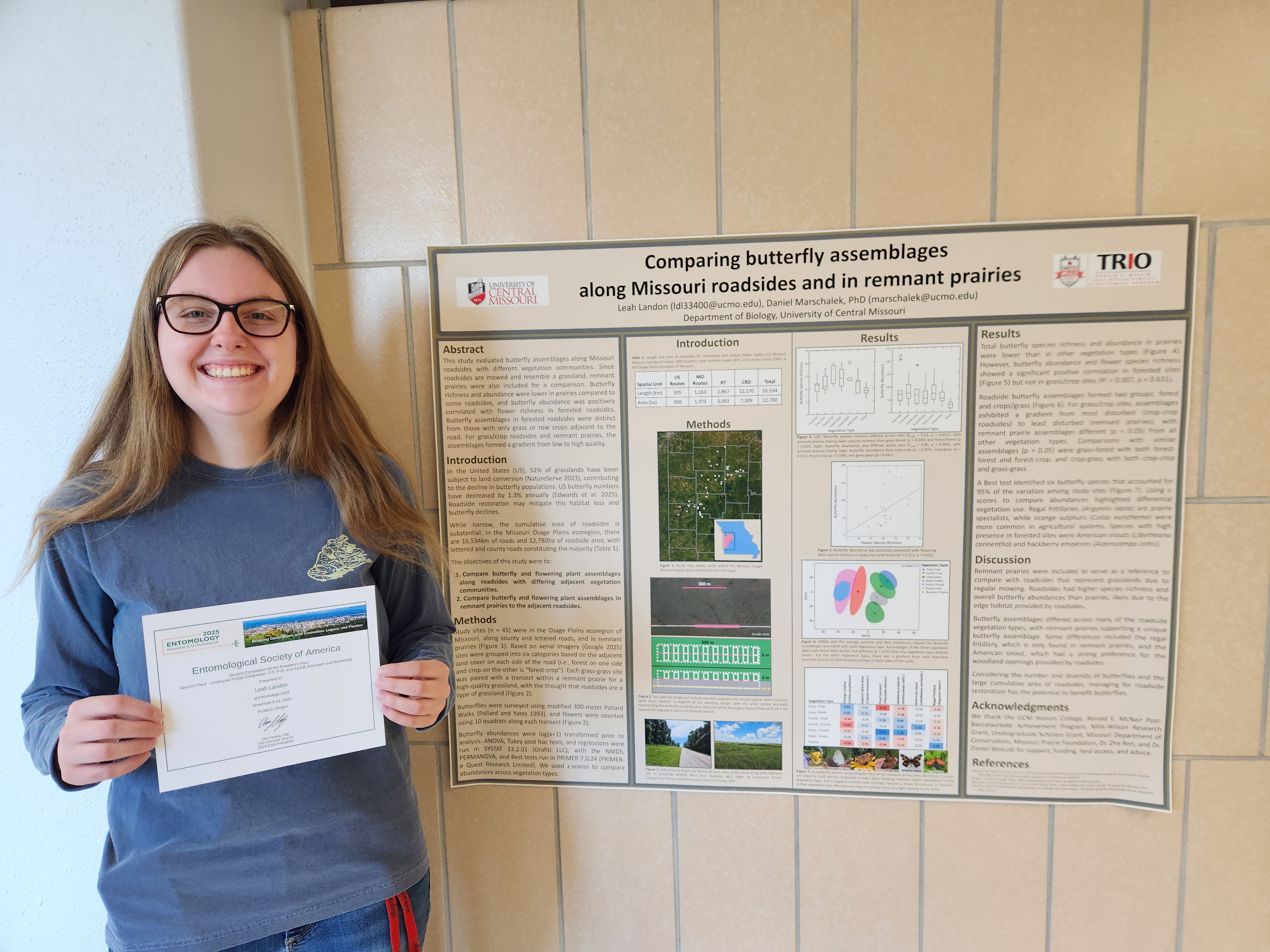 Leah Landon holds her award certificate next to her research poster