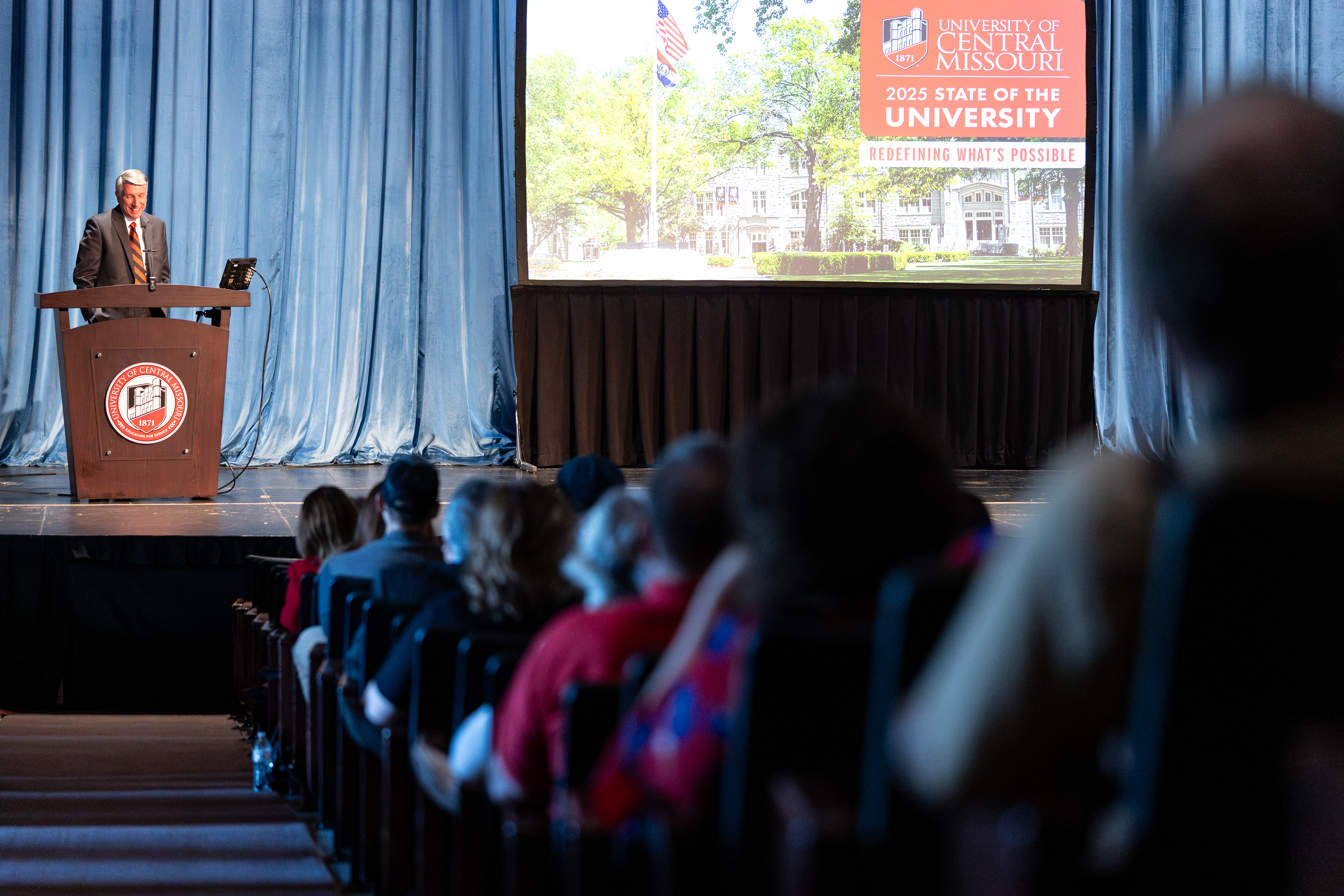 A crowd in Hendricks Hall listen's to UCM President Roger Best's speech