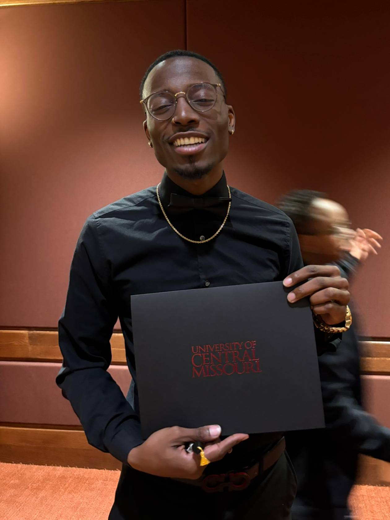 Student smiles while holding UCM certificate