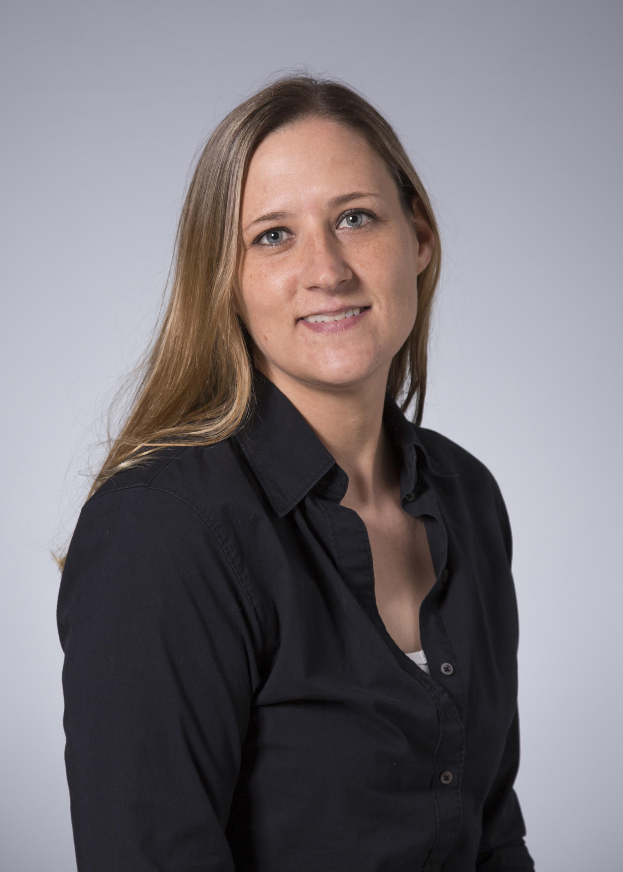 Dawn Pauling A person is seen in a professional portrait wearing a black shirt in front of a gray background.