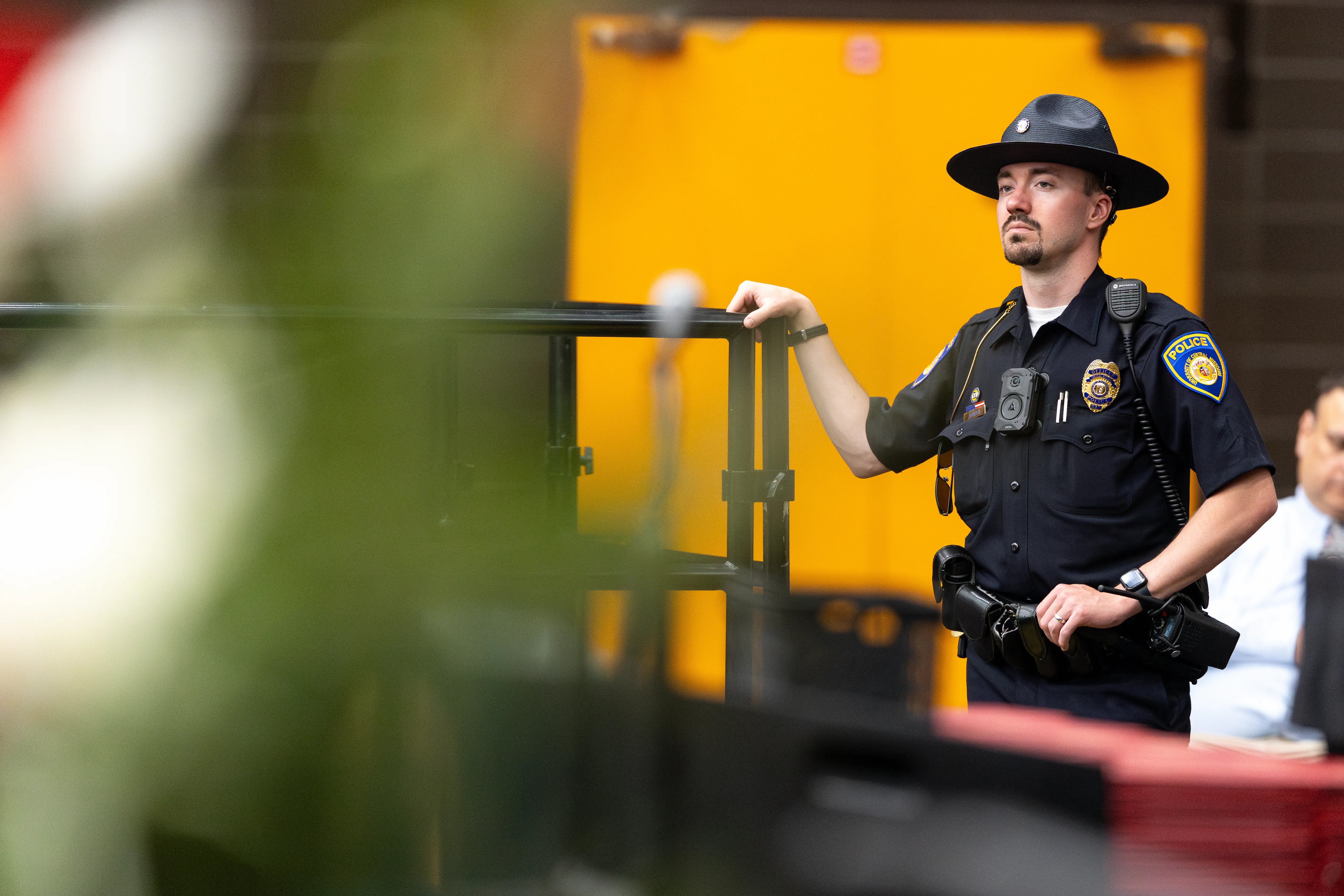 A UCM Public Safety officer is seen in his dark navy police uniform and hat while on duty in the athletics center for an event.