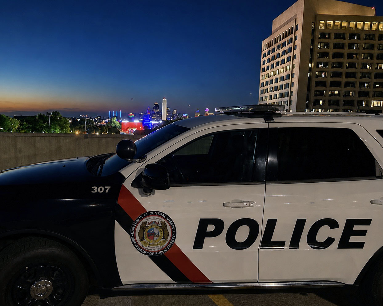 A vehicle is seen at night on the top level of a parking garage. The car is white and black, says 