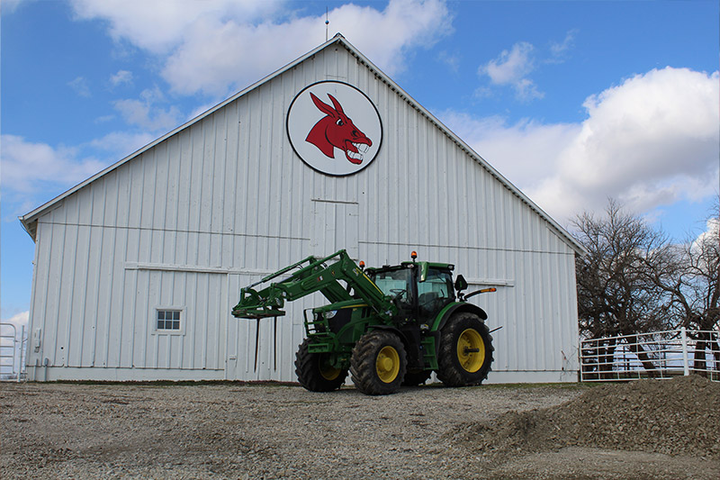 A tractor in front of a barn