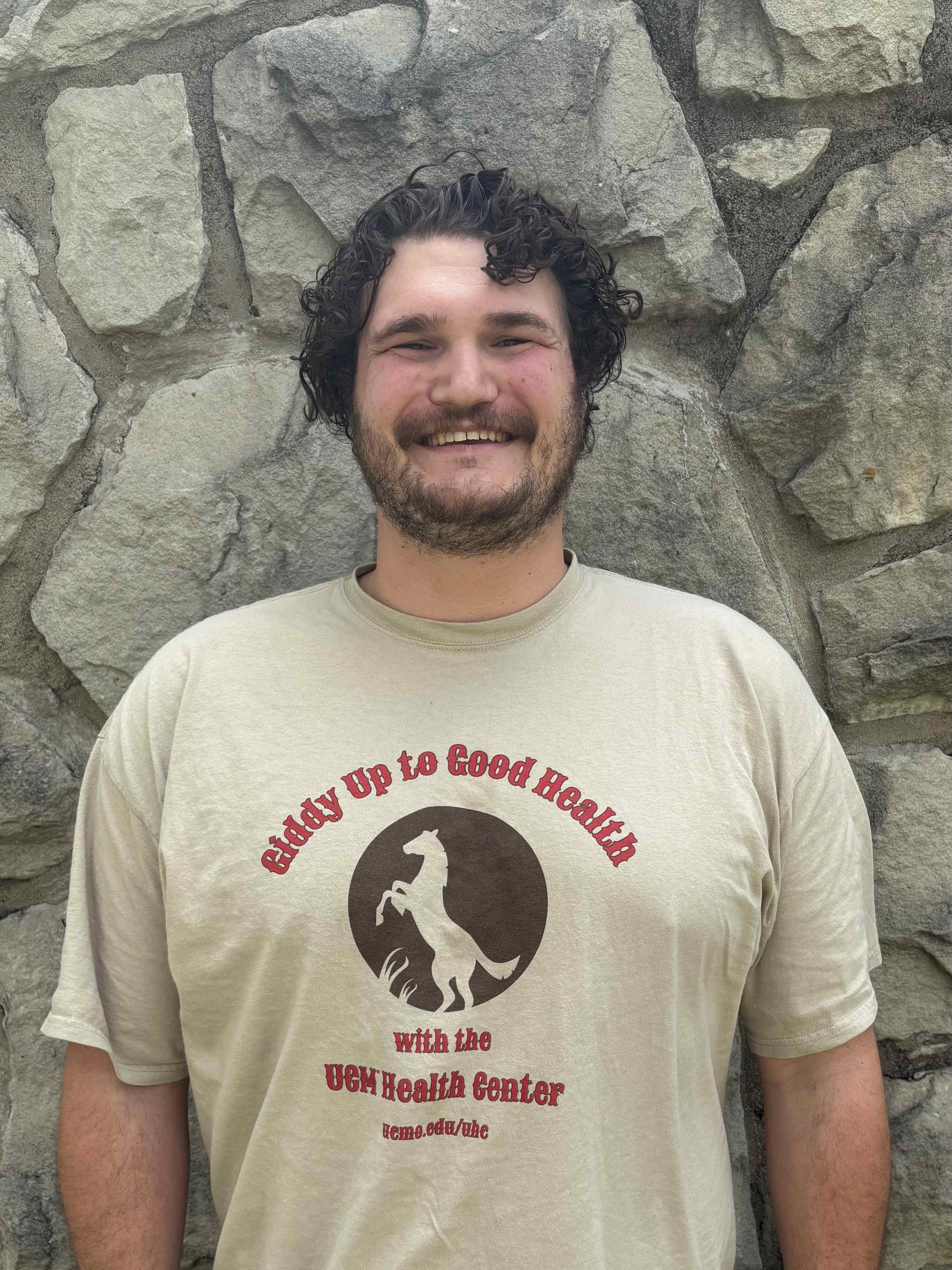 Noah Roberts standing in front of rock wall