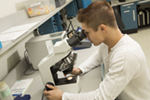 student looking through magnifying glass