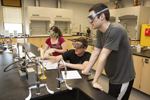 three students working in chemistry lab