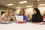 three females sitting at desk together