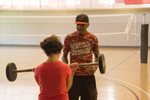 student lifting barbell