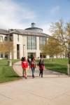 students walking on sidewalk outside of James C. Kirkpatrick library